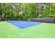 Outdoor tennis court with professional surface surrounded by trees at 1114 Waterford Green Pt, Marietta, GA 30068