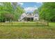 Spacious backyard featuring a well-maintained lawn, wooden fence, and treeline, ideal for outdoor activities at 1275 Smokehouse Trl, Cumming, GA 30041
