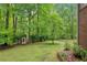 Large, wooded backyard with a storage building and partial fence at 1275 Smokehouse Trl, Cumming, GA 30041