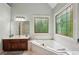 Well-lit bathroom featuring a large tub and decorative glass window at 1275 Smokehouse Trl, Cumming, GA 30041