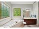 Bright bathroom with a soaking tub under leaded glass windows and double vanity sinks at 1275 Smokehouse Trl, Cumming, GA 30041
