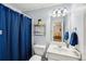 A bathroom featuring a vanity, toilet, and shower with blue accent details at 1275 Smokehouse Trl, Cumming, GA 30041