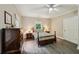 Bedroom features a ceiling fan, tan walls, wood look flooring, and two windows with views of greenery at 1275 Smokehouse Trl, Cumming, GA 30041