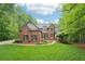 Beautiful brick home with a lush green lawn and mature trees at 1275 Smokehouse Trl, Cumming, GA 30041
