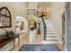 Elegant foyer with hardwood floors, staircase, and arched doorways to other rooms at 1275 Smokehouse Trl, Cumming, GA 30041
