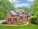 Charming two-story brick home featuring lush landscaping, manicured lawn, and inviting front entrance at 1275 Smokehouse Trl, Cumming, GA 30041