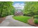 Beautiful home with a long driveway, lush green lawn, and surrounded by mature trees for privacy at 1275 Smokehouse Trl, Cumming, GA 30041