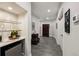 Hallway features a wet bar with mini fridge and glass shelving, with grey wood look flooring at 1275 Smokehouse Trl, Cumming, GA 30041