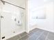 Sleek bathroom with glass-enclosed shower, soaking tub, and modern gray tile flooring at 1712 Fulmont Cir, Mableton, GA 30126
