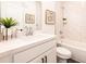 Bright bathroom with white vanity, decorative mirror, and a bathtub with a shower at 1712 Fulmont Cir, Mableton, GA 30126