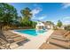 Community pool featuring comfortable lounge chairs and surrounded by lush trees under a blue sky at 1712 Fulmont Cir, Mableton, GA 30126