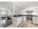 Open-concept kitchen with white cabinetry, stainless steel appliances, and an adjacent living area at 1850 Cotillion Dr # 3114, Atlanta, GA 30338
