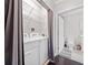 Laundry area with a washer, dryer, metal shelving and an adjacent full bathroom at 1850 Cotillion Dr # 3114, Atlanta, GA 30338