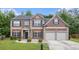 Charming two-story brick home with a well-manicured lawn and a two-car garage at 3225 Rex Ridge Dr, Rex, GA 30273