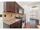 Stylish kitchen featuring stainless steel appliances, granite countertops, and dark wood cabinets at 3225 Rex Ridge Dr, Rex, GA 30273