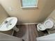 Small bathroom with a pedestal sink, toilet and vinyl flooring at 1822 Millwood Park Ct, Buford, GA 30518