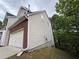 Exterior elevation featuring attached garage, brick and vinyl siding, with a large, grassy yard at 1822 Millwood Park Ct, Buford, GA 30518