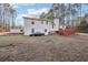 Spacious backyard featuring a two-story white home with a charming wooden deck and mature trees at 2248 Bethel Rd, Conyers, GA 30012