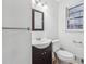 Bathroom featuring a dark vanity, square mirror, white toilet, and a double hung window at 2248 Bethel Rd, Conyers, GA 30012