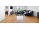 Bright living room boasts hardwood floors, a large window, and a comfortable leather sectional at 2965 Pharr Court South Nw # 1-817, Atlanta, GA 30305