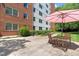 Exterior of building features patio with table under umbrella, and manicured lawn and landscaping at 2965 Pharr Court South Nw # 1-817, Atlanta, GA 30305