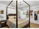 Comfortable primary bedroom with a four post bed, bright light fixture and windows with natural light at 3331 Doyle Sw Ln, Marietta, GA 30060