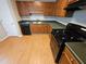 Functional kitchen with wood cabinets, black appliances, and laminate countertops at 71 Streamview Trl, Douglasville, GA 30134