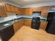 Spacious kitchen featuring wood cabinets, black appliances and countertops at 71 Streamview Trl, Douglasville, GA 30134
