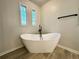 Bathroom featuring standalone tub and decorative windows at 894 Oak Rd, Lawrenceville, GA 30044