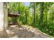 Back patio with view of mature trees and under deck seating area at 150 Park Creek Dr, Alpharetta, GA 30005