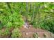 A lush backyard with green trees, plants and a stone walkway through the garden at 150 Park Creek Dr, Alpharetta, GA 30005