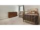 Comfortable bedroom featuring a vintage metal bed frame, dresser, and a cozy chair at 6330 Beaver Crossing Dr, Cumming, GA 30040