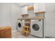 Convenient laundry room with side-by-side washer and dryer and ample cabinet storage at 6330 Beaver Crossing Dr, Cumming, GA 30040