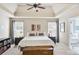 Elegant main bedroom with tray ceiling, ceiling fan, natural light, and en-suite bathroom at 6330 Beaver Crossing Dr, Cumming, GA 30040