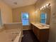 Bathroom boasts dual sinks, a soaking tub, and a window with natural light at 110 Slate Ridge Ln, Loganville, GA 30052