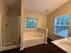 Primary bathroom featuring a glass shower, garden tub, vanity, and large window at 110 Slate Ridge Ln, Loganville, GA 30052