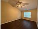 Bedroom with vaulted ceiling features a large window and neutral paint with dark vinyl floors at 110 Slate Ridge Ln, Loganville, GA 30052