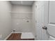 Laundry room features white walls, hardwood floors, and a storage shelf at 110 Slate Ridge Ln, Loganville, GA 30052