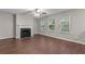 Inviting living room with fireplace, ceiling fan and large windows with green backyard views at 110 Slate Ridge Ln, Loganville, GA 30052