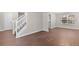 View of the home's entrance and staircase from the open-concept living area with wood flooring at 110 Slate Ridge Ln, Loganville, GA 30052