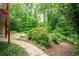Lush backyard featuring mature trees, manicured shrubs, and a stone walkway, creating a serene outdoor space at 2980 Milford Sw Trl, Marietta, GA 30008