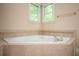 Bathroom featuring soaking tub and ceramic tile surround at 2980 Milford Sw Trl, Marietta, GA 30008