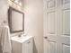 Compact bathroom features a single vanity, framed mirror, and a bright white door at 3812 Maclaren Dr, Clarkston, GA 30021