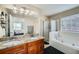 Bathroom showcasing double sinks, granite countertop, a bathtub, and a glass-door shower at 3812 Maclaren Dr, Clarkston, GA 30021