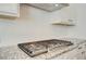 Close up of the modern cooktop with granite countertops and white cabinets in the kitchen at 3890 Ivy Cottage Dr, Snellville, GA 30039