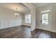Bright dining room with dark hardwood floors, wainscoting detail, and modern chandelier at 3890 Ivy Cottage Dr, Snellville, GA 30039
