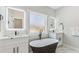 Bright bathroom features double sinks, a freestanding tub, and a frosted window for privacy at 665 Ferris St, Atlanta, GA 30310