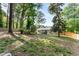 A spacious backyard with mature trees and a fence. It also features a patio with outdoor furniture at 874 Fox Valley Dr, Stone Mountain, GA 30088