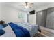 Bedroom with a ceiling fan, mounted TV, a bed with blue bedding, and double closet doors at 874 Fox Valley Dr, Stone Mountain, GA 30088