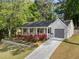 Attractive single-Gathering home featuring a welcoming front porch, a neat lawn, and colorful rose bushes at 874 Fox Valley Dr, Stone Mountain, GA 30088